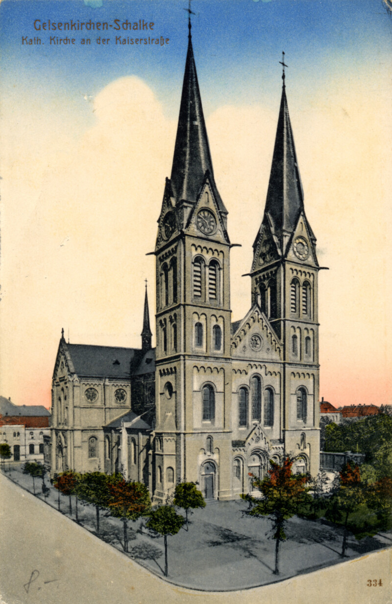 Eine Postkartenansicht der St.-Joseph-Kirche um 1910. Sie zeigt die beiden Kirchtürme mit ihren alten Kirchturmspitzen. Sie sind höher und spitzer als die Türme heute.