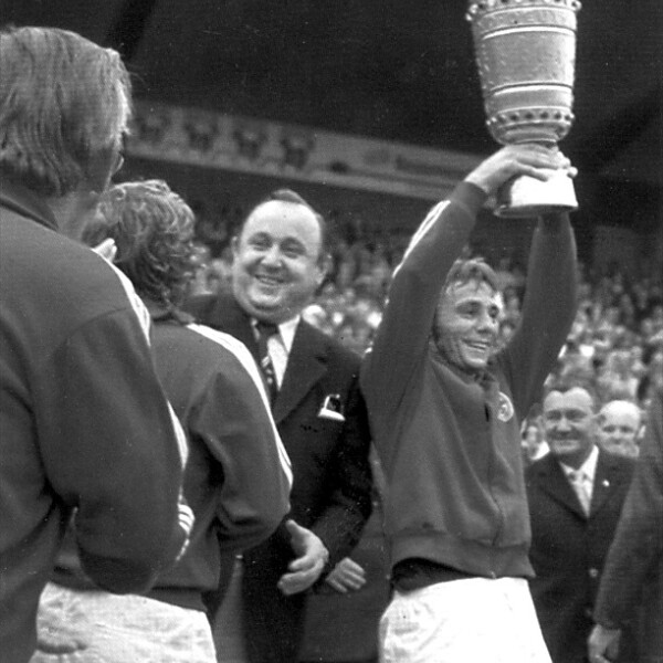 Der Kapitän des FC Schalke 04, Reinhard "Stan" Libuda, reißt den DFB-Pokal in einem vollbesetzten Stadion in die Höhe.