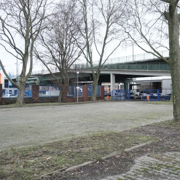 Der Schalker Markt ist nur noch ein leerer, unbelebter Parkplatz. Im Hintergrund ist die Berliner Brücke zu sehen.