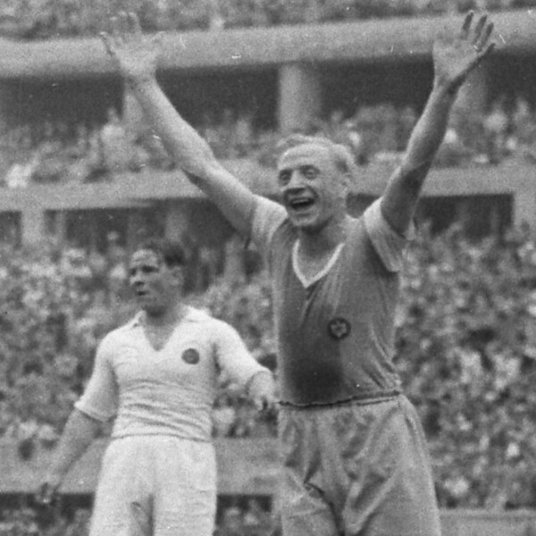 Fritz Szepan vom FC Schalke 04 steht 1939 beim Finale um die Deutsche Meisterschaft im vollen Berliner Olympiastadion. Er reißt jubelnd die Arme in die Luft. Hinter ihm steht ein Gegenspieler.