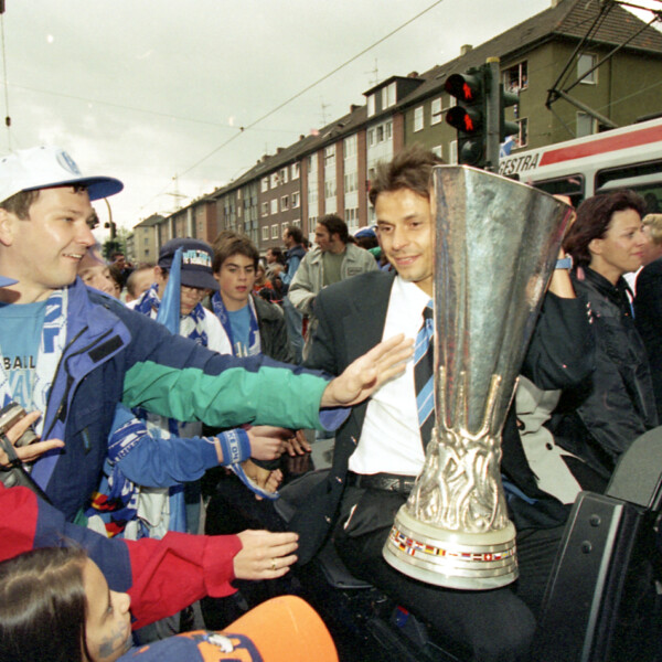 Olaf Thon steht mit dem UEFA-Pokal auf der Schalker Meile. Er ist umringt von Fans des FC Schalke 04.