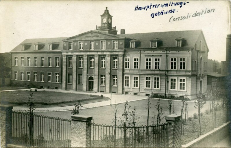 Ein dreigeschossiges Verwaltungsgebäude. Der Eingangsbereich ist mit sechs Säulen ausgestattet. Auf dem Dach befindet sich eine kleine Turmuhr. Über dem Gebäude ist handschriftlich "Hauptverwaltungsgebäude Consolidation" vermerkt.