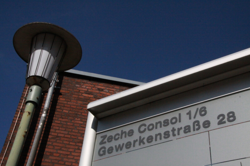 Detailaufnahme eines Schilds an der Gewerkenstraße in Schalke. Auf dem Schild steht "Zeche Consol 1/6; Gewerkenstraße 28".
