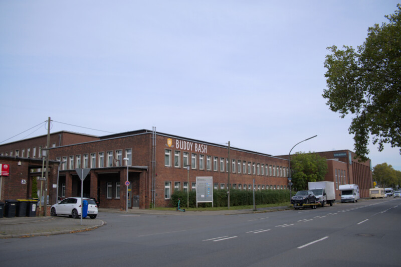 Ein zweigeschossiger Flachbau der ehemaligen Zeche Consolidation an der Gewerkenstraße in Schalke. An dessen Fassade die Aufschrift "Buddy Bash" angebracht ist.