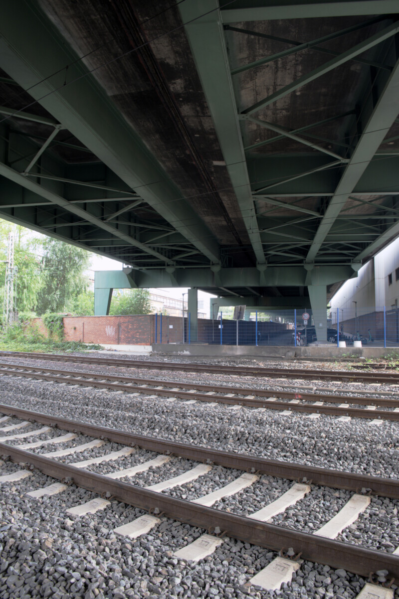 Unteransicht der Berliner Brücke. Unter ihr liegen drei Schienenstränge. Sie kreuzen den Verlauf der Brückenfahrbahn.